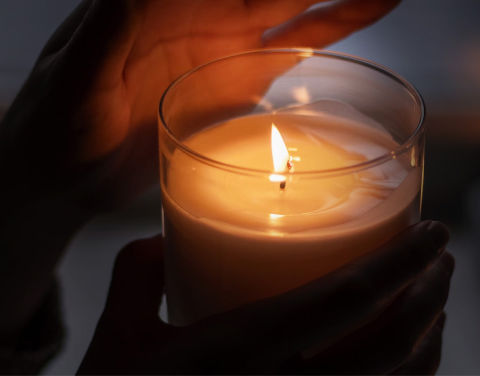 Teelicht, das eine Hand beleuchtet